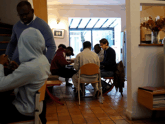 Jeunes rassemblés autour d'une table avec deux accompagnants