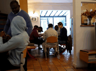 Jeunes rassemblés autour d'une table avec deux accompagnants