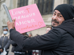 Homme sans abris qui tient une pancarte