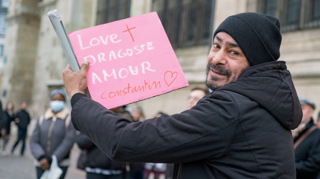 Homme sans abris qui tient une pancarte